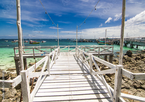 The white wooden bridge  the destination is a beautiful sea with blue sky.
