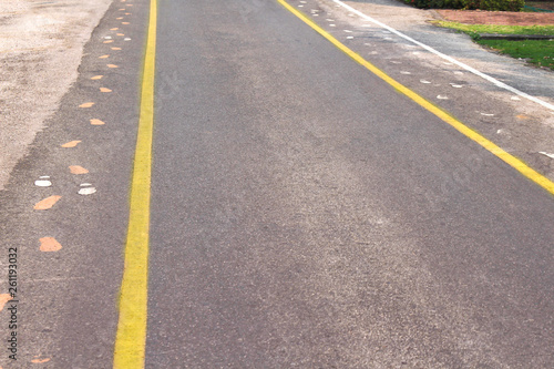 Asphalt road with two yellow lines and sidewalk mark  , white and © Amphawan