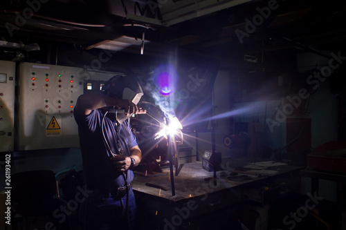 Welding technician, carrying out welding work in the workshop