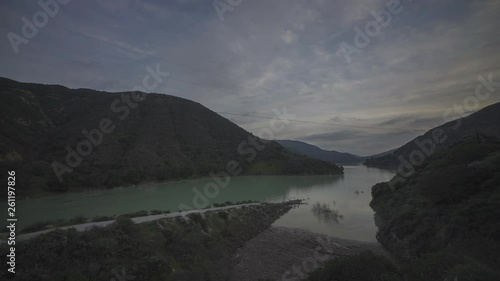 Time lapse of clouds over he ridge of mountains dam water that looks like an ocean photo