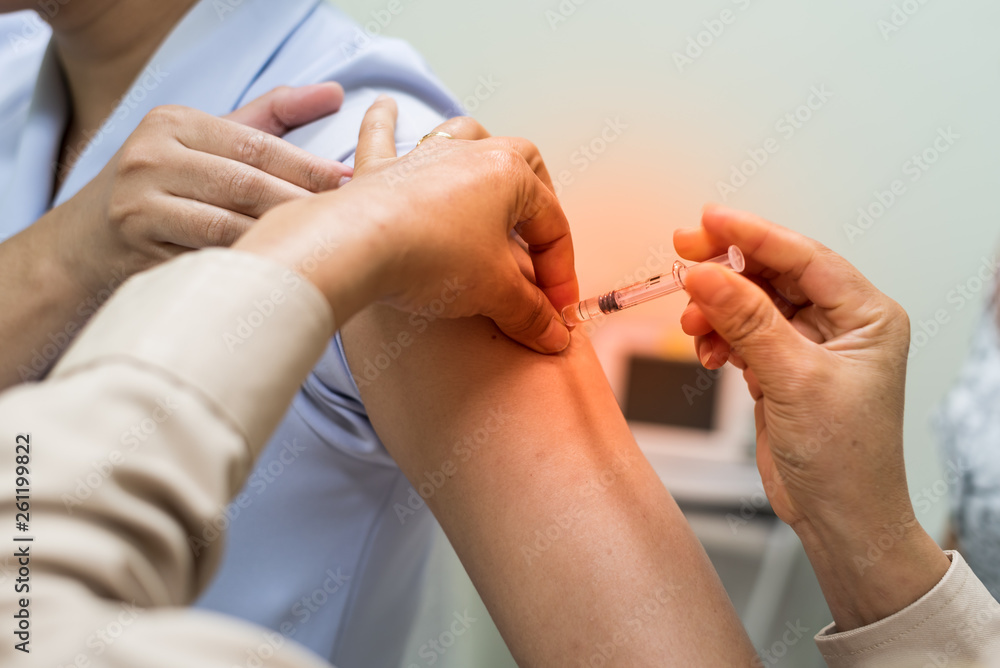 Vaccination for women in vaccine room.Doctor hand holding and injecting needle for HPV women vaccine. Medical concept