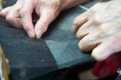 Amami Oshima, Japan - April 6, 2019: Weaving Oshima Tsumugi made of silk thread. Traditional pongee in Amami Oshima.  photo