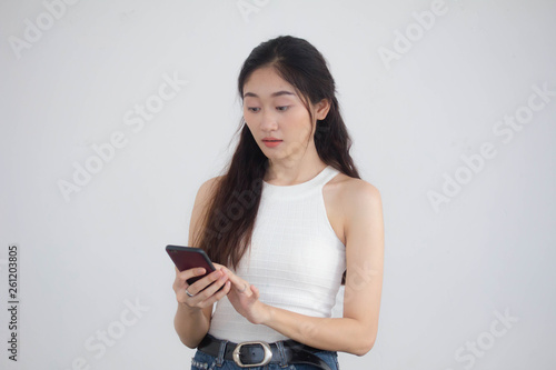 Portrait of thai china adult beautiful girl White shirt blue jeans using her smart phone