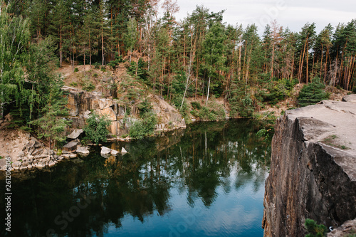 Fototapeta Naklejka Na Ścianę i Meble -  Lake on the background of rocks and fir trees. Canyon. The nature of autumn. Place for text and design. Landscape of an old flooded industrial granite quarry filled with water.