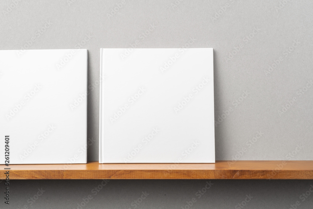 2 white square notebook on bookshelf and grey wall 2 white square notebook on bookshelf and grey wall