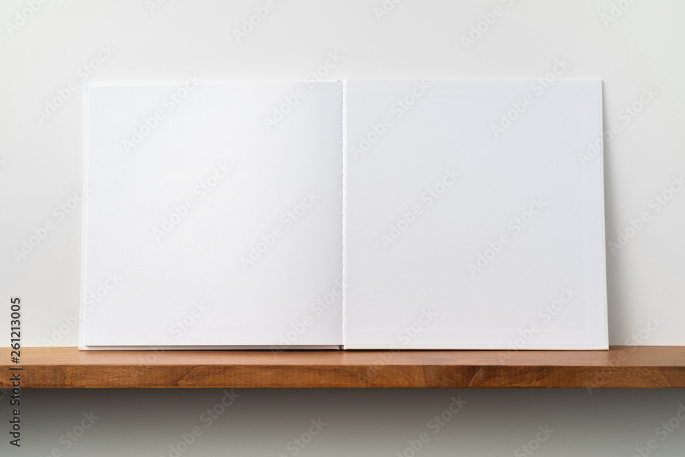 white square notebook on bookshelf and white wall white square notebook on bookshelf and white wall