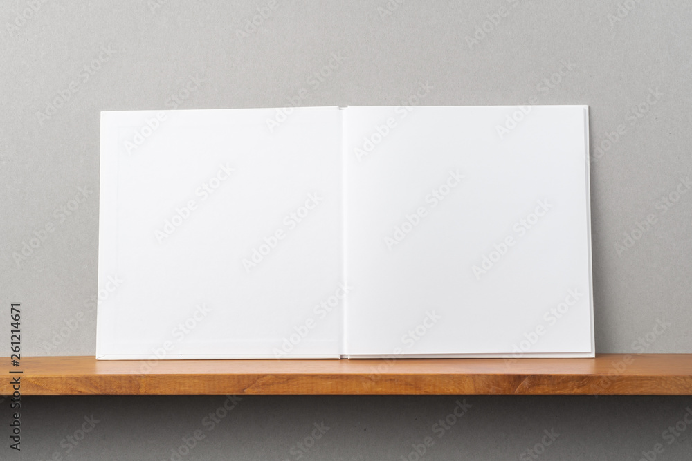 white square notebook on bookshelf and grey wall white square notebook on bookshelf and grey wall