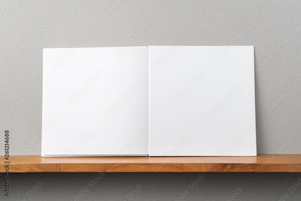 white square notebook on bookshelf and grey wall white square notebook on bookshelf and grey wall