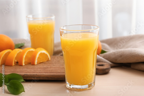 Glass of freshly squeezed orange juice on wooden table