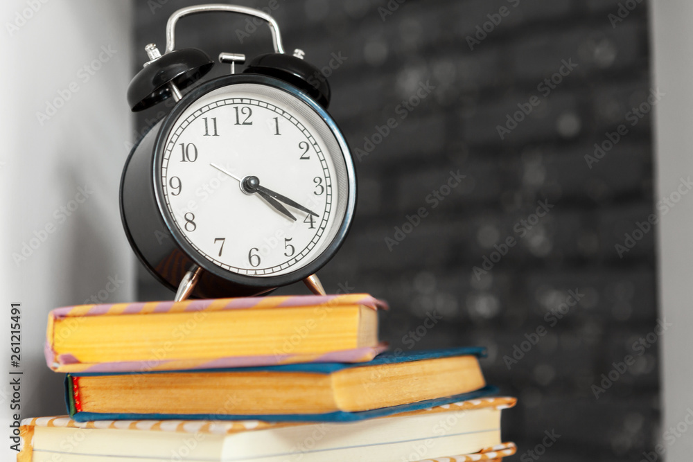 alarm clock near books on the table alarm clock near books on the table