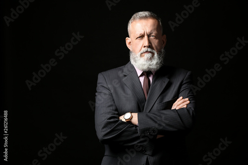 Handsome mature businessman on dark background