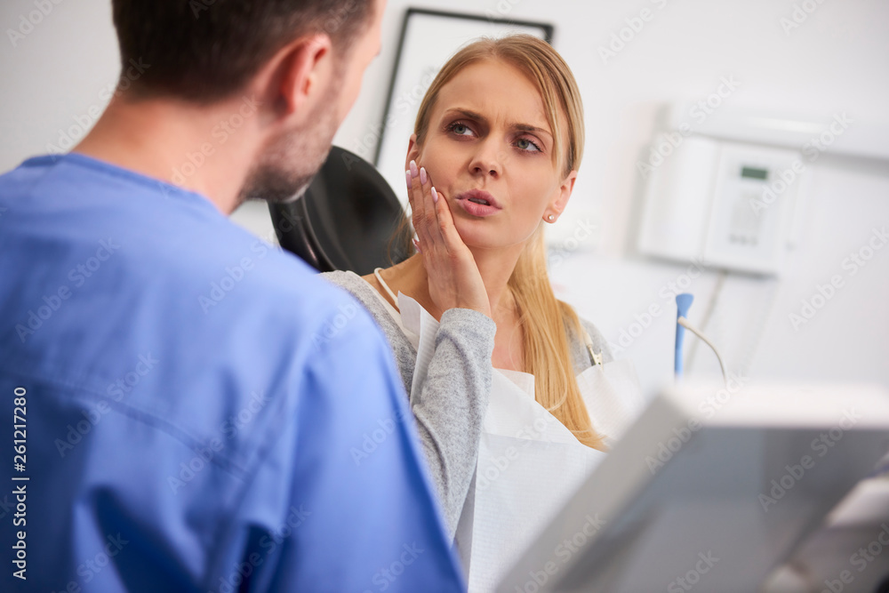Woman with toothache talking to dentist Woman with toothache talking to dentist