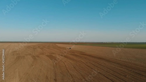 Aerial view on farm field with tractor. Agronomic activities in spring photo