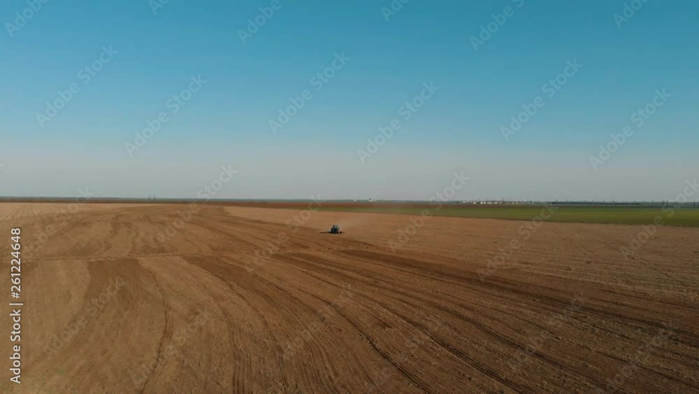 Peasant field with tractor near provincial village. Agronomic activities in spring Peasant field with tractor near provincial village. Agronomic activities in spring