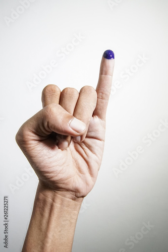 Inked blue finger of a man hand isolated on white background. blue ink blots from voters finger presidential election (pilpres) of indonesia. photo