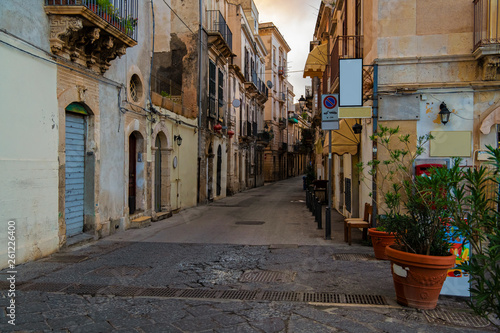 Fototapeta Naklejka Na Ścianę i Meble -  Typical italian narrow street with flower pots in the island of Ortigia, Syracuse, Sicily, Italy