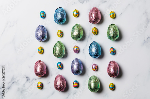 Easter egg chocolate treats wrapped in shiny coloured foil on  marble background