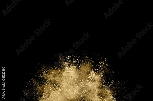 Golden powder explosion on black background. Freeze motion.