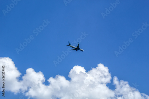 The plane flies in the sky with clouds. © Anasty