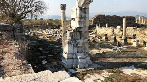Tourist walks among ruins of ancient city Magnesia, Aydin Province, Turkey.