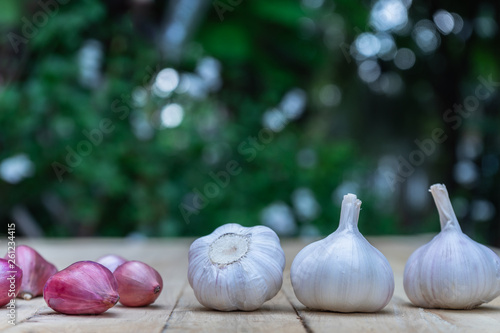 Fototapeta Naklejka Na Ścianę i Meble -  Top view of herbal vegetable ingredients, fresh garlic and red onion, on old wooden table, cooking preparation concept