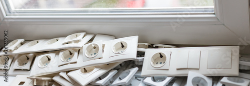 Tv coaxial sockets and the stack of socket frames on the light windowsill photo