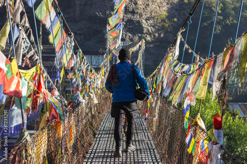 Nepal, Chame village 08.06.2018,editorial use only. male tourist walks over the bridge