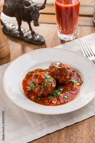 Meatballs in sweet and sour tomato sauce on wooden table