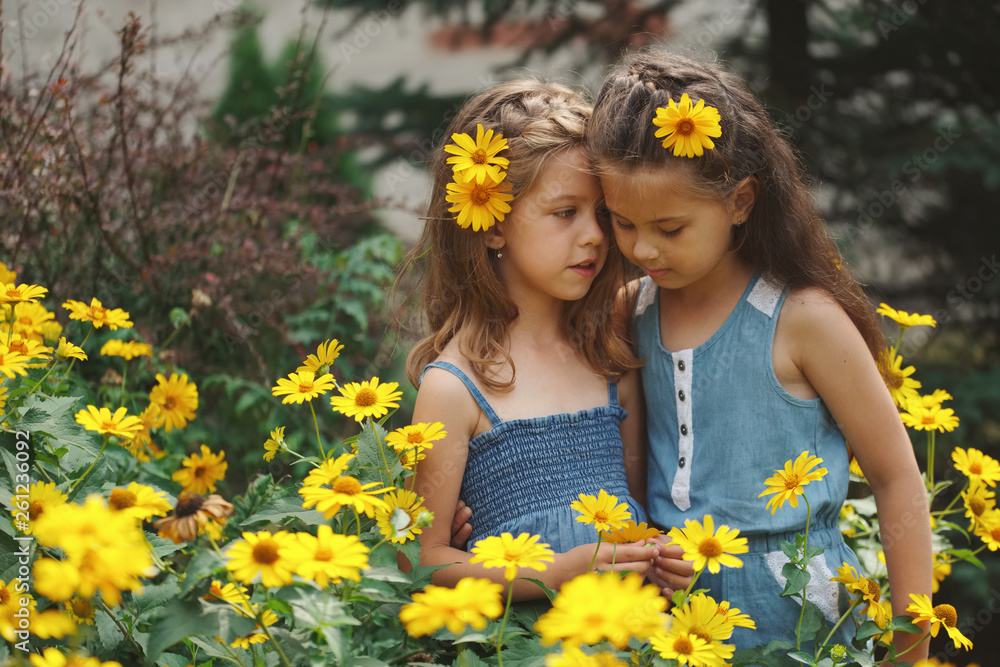 portrait of happy beautiful girls in flowerbed