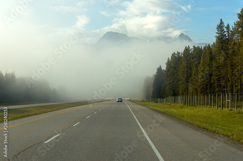 Fog on the Highway with view of mountain and blue sky, Driving into Banff National Park, Alberta, Canada