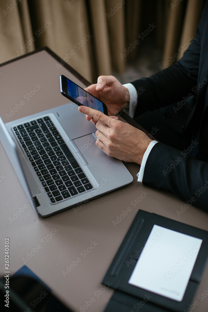 Manager on his laptop and phone. Boss at the desk, typing on laptop, using phone. Manager on his laptop and phone. Boss at the desk, typing on laptop, using phone.