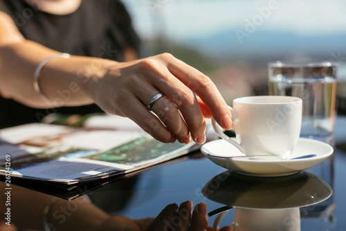 Woman at a restaurant holding a cup of coffee.