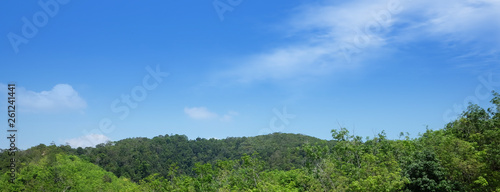 A summer alpine panorama of a wide thai valley with cloudy sky  haze and fresh green pastures 