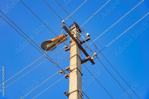 street pole with wires and a lantern against a blue sky