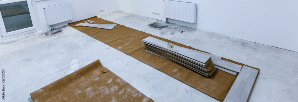 Installing light laminate floor with substrate under a laminate on white background Installing light laminate floor with substrate under a laminate on white background