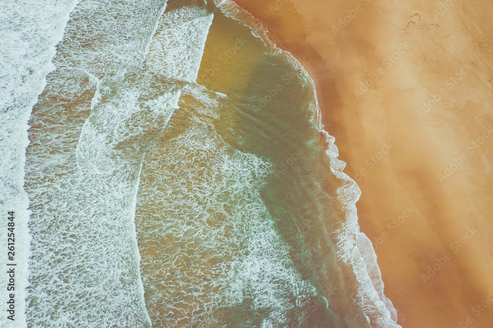 Aerial view to ocean waves. Yellow sand beach. Blue water background. Photo made from above by drone. Aerial view to ocean waves. Yellow sand beach. Blue water background. Photo made from above by drone.