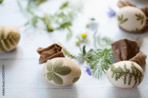 Easter eggs with pressed leaves and flowers, prepared to be dyed