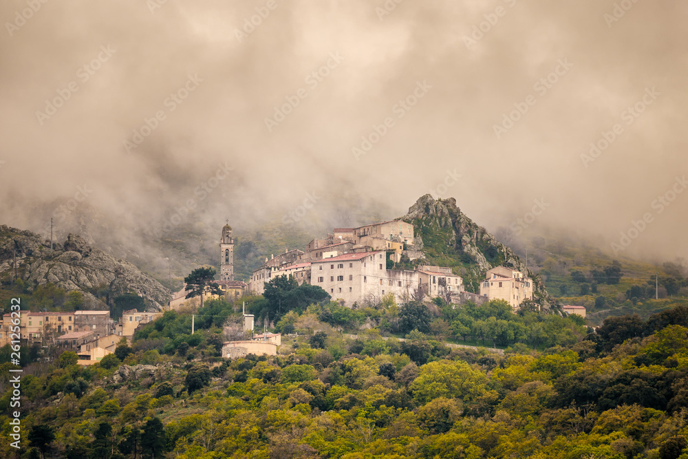 Clouds over mountain village of Speloncato in Corsica