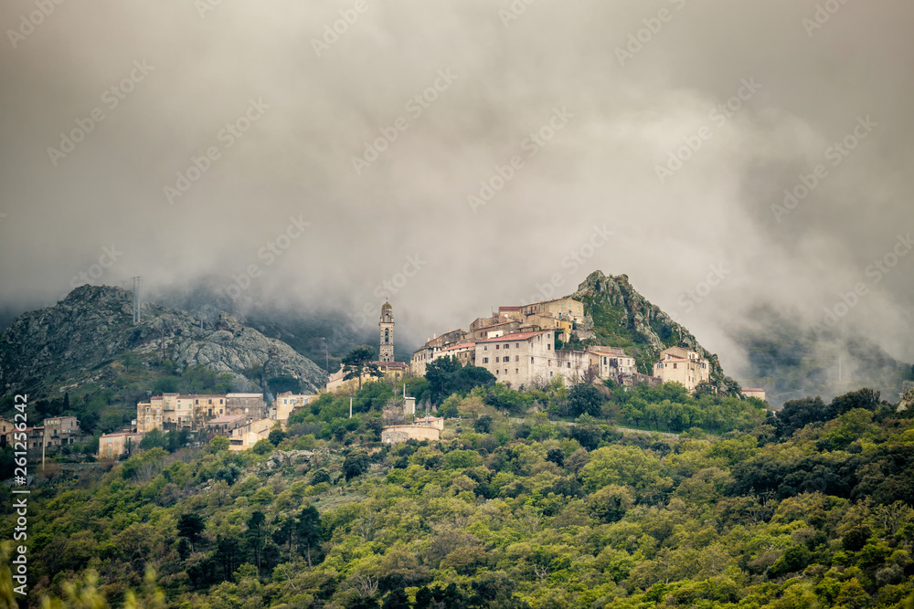 Clouds over mountain village of Speloncato in Corsica