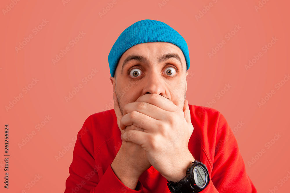 Expressive scared guy with wide open eyes clutching his face Expressive scared guy with wide open eyes clutching his face