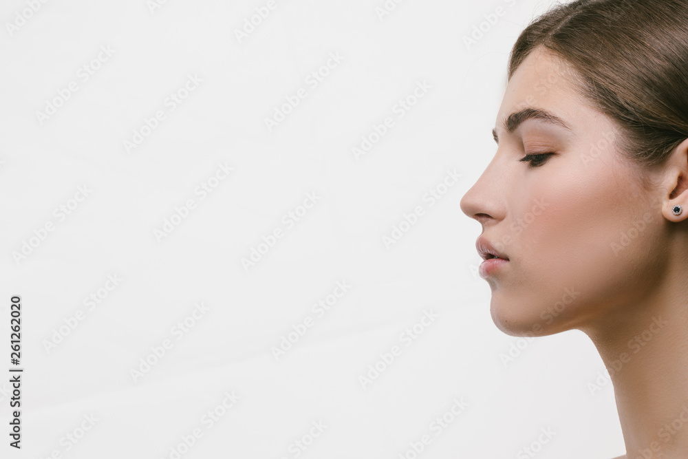 Beauty Spa Woman with perfect skin Portrait. Beautiful Brunette Spa Proposing a product. Gestures for advertisement. Beige background Beauty Spa Woman with perfect skin Portrait. Beautiful Brunette Spa Proposing a product. Gestures for advertisement. Beige background