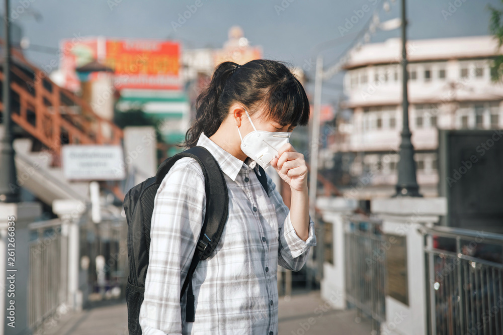 Asian woman wearing face mask coughing because of air pollution in
