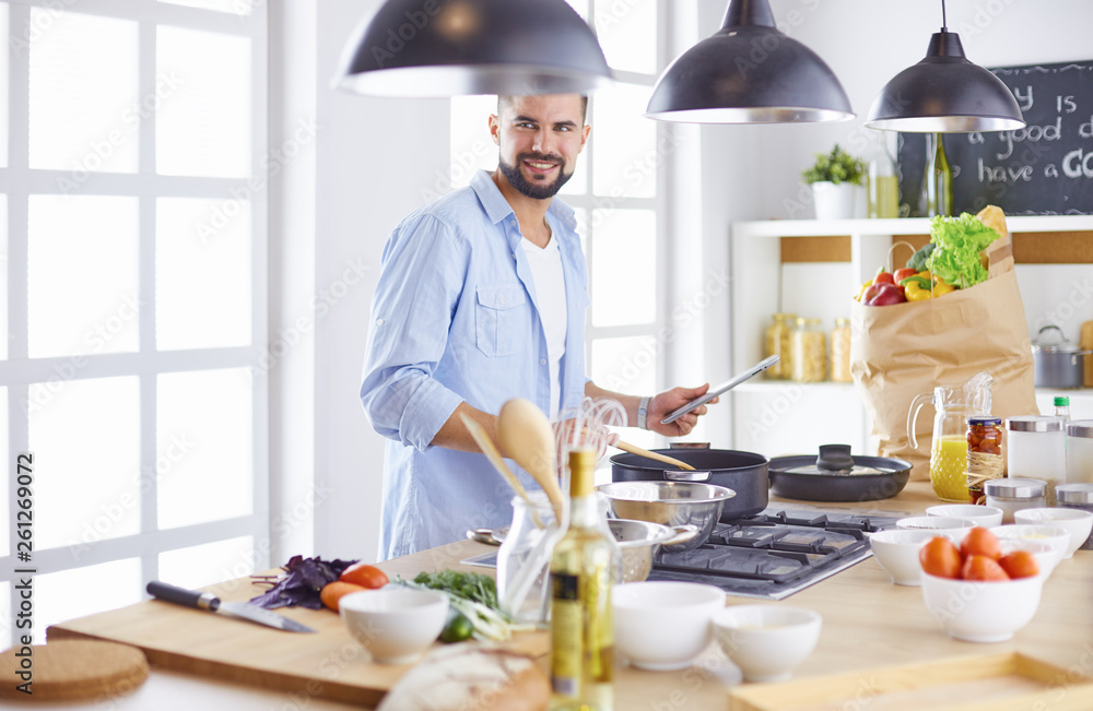 Smiling and confident chef standing in large kitchen Smiling and confident chef standing in large kitchen