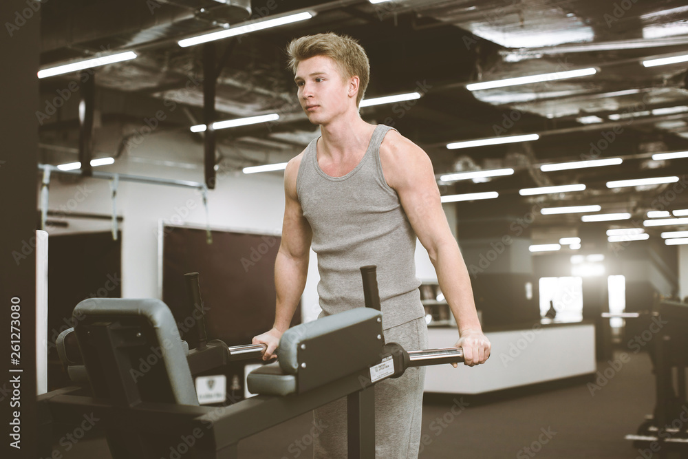 Strong muscular bodybuilder doing exercise on bars in the gym. Part of fitness body. Sports and fitness. Fitness man in the gym. Fitness training Strong muscular bodybuilder doing exercise on bars in the gym. Part of fitness body. Sports and fitness. Fitness man in the gym. Fitness training