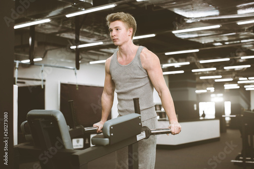 Strong muscular bodybuilder doing exercise on bars in the gym. Part of fitness body. Sports and fitness. Fitness man in the gym. Fitness training