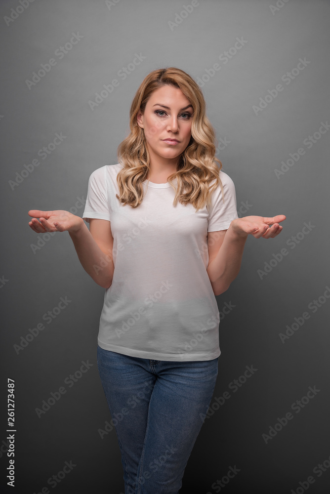 A young woman raises her hands up showing surprise or denial. A young woman raises her hands up showing surprise or denial.