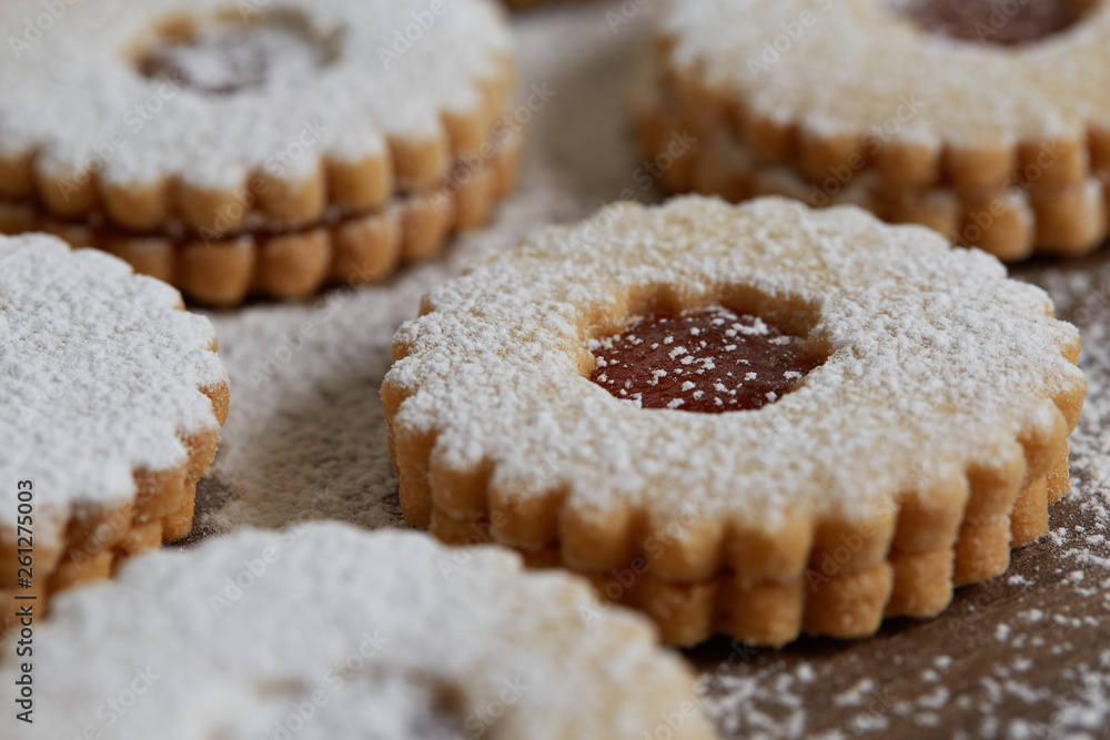 Close up of freshly baked homemade Christmas sugar cookies with jam on a wooden background Close up of freshly baked homemade Christmas sugar cookies with jam on a wooden background