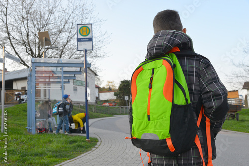 Schüler mit Schulrucksack der Grundschule auf dem morgendlichen Weg zum Schulbus photo