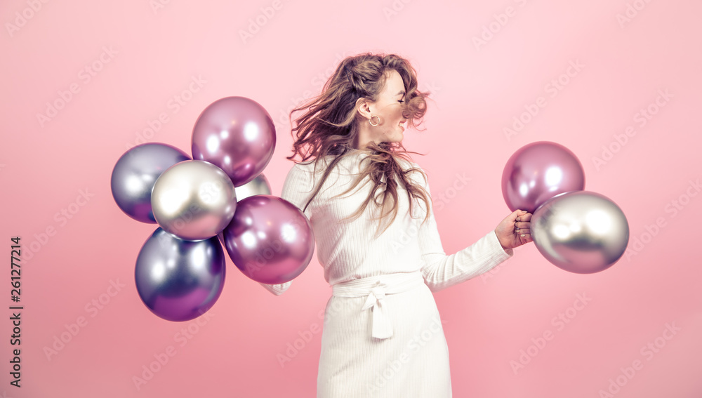 Fototapeta premium Young girl with balls on a colored background