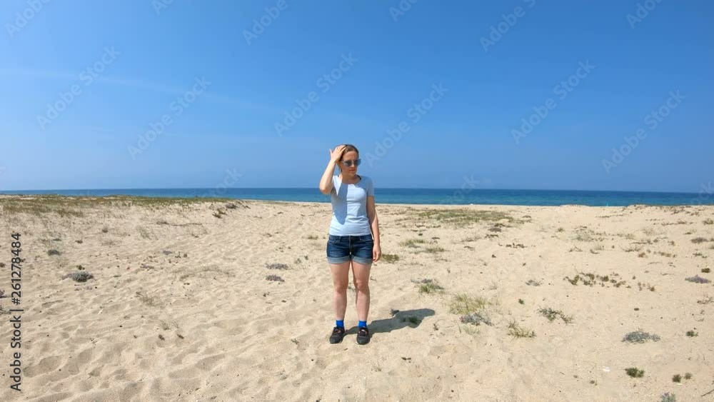 Girl on the shore of lake Baikal. Young woman stands on the sandy beach of lake Baikal Girl on the shore of lake Baikal. Young woman stands on the sandy beach of lake Baikal